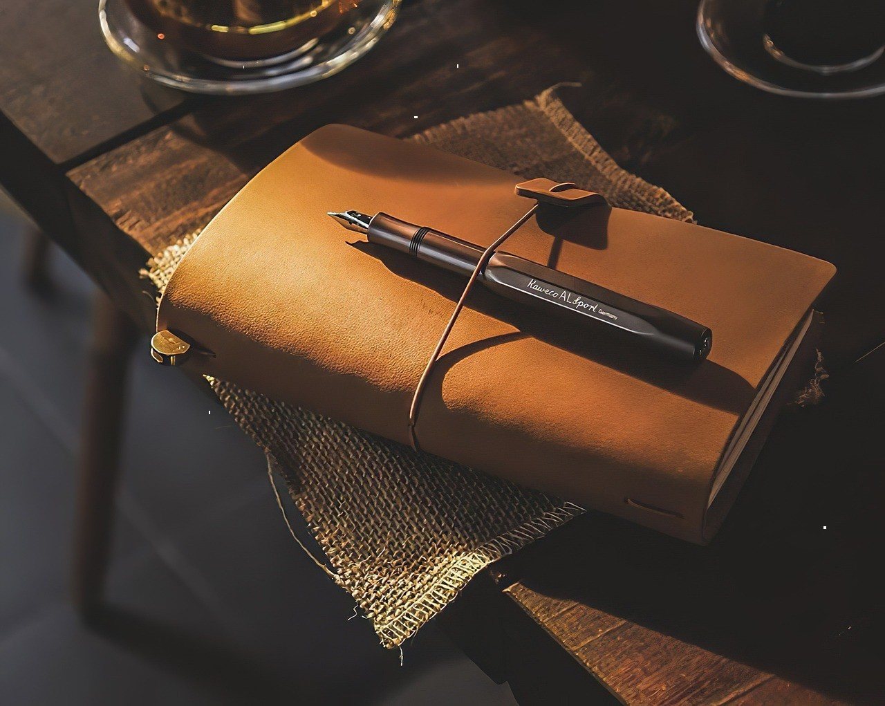Leather-bound sketchbook with a pen resting on top